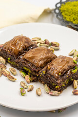 Chocolate baklava with pistachio on a white background. Traditional Mediterranean cuisine delicacies. Close-up Chocolate Baklava. local name cikolatali baklava