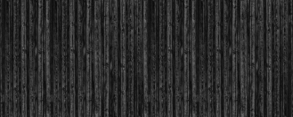 Black old shabby wooden board wide panoramic texture. Dark gray rough knotty wood plank backdrop. Abstract gloomy grunge large banner background