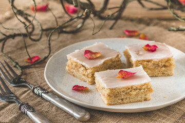 Pieces of covered apple pie with icing on a rustic wooden background