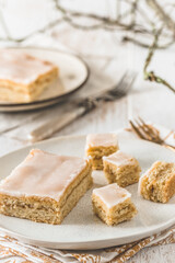 Piecse of covered apple pie with sugar icing on a white wooden background