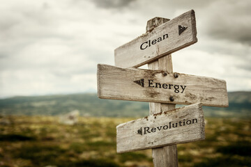 clean energy revolution text quote written in wooden signpost outdoors in nature. Moody theme feeling.