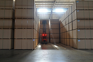 Workers drive forklifts to transport density board products in the factory, North China