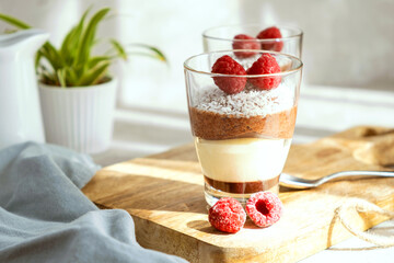 Three-layer mousse dessert made of chocolate and vanilla, decorated with fresh raspberries and...
