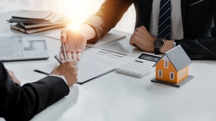 Rental company employee is discussing the details before the customer agrees to sign a rental contract, explaining the details and the terms and conditions of the rental. Real estate rental ideas.