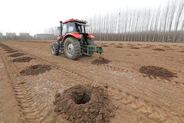 Farmers use machines to drill tree holes for afforestation activities during the Spring Festival in...