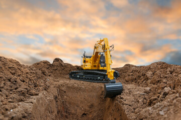 Selective focus ,Excavator with Bucket  are digging canalize the soil in the construction site on the sky  background