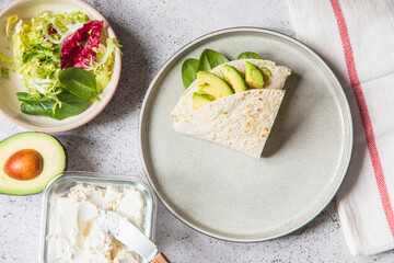 Cooking process for sandwich and ingredients. Process of prepare quesadilla with avocado, salmon, curd cheese and spinach. Trendy wrap hack. Step by step. Step 4