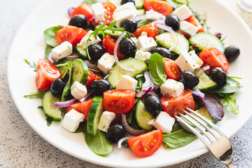 Greek salad of fresh cucumber, tomato, red onion, feta cheese and olives with olive oil. Healthy food, top view