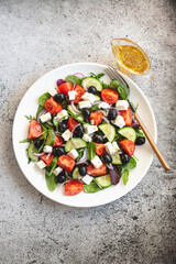Fototapeta na wymiar Greek salad of fresh cucumber, tomato, red onion, feta cheese and olives with olive oil. Healthy food, top view