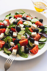 Greek salad of fresh cucumber, tomato, red onion, feta cheese and olives with olive oil. Healthy food, top view