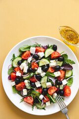 Greek salad of fresh cucumber, tomato, red onion, feta cheese and olives with olive oil. Healthy food, top view