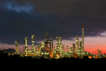 Obraz na płótnie Canvas Oil​ refinery​ and​ plant and tower column of petrochemistry industry in pipeline oil​ and​ gas​ ​industry with​ sun red sky the morning