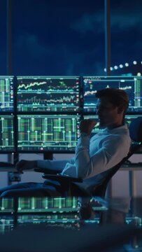 Vertical Portrait of Financial Analyst Working on Computer with Multi-Monitor Workstation with Real-Time Stocks, Commodities and Foreign Exchange Charts. Businessman Works in Investment Bank.