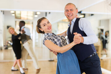 Happy man and woman enjoying ballroom dancing
