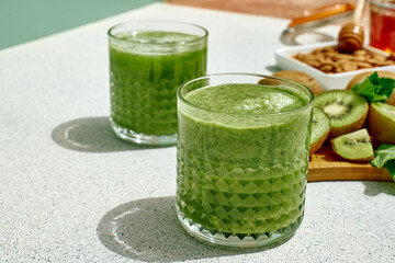 Green smoothie with kiwi fruit in the glasses. Healthy organic drink. Nutrition and alkaline diet....