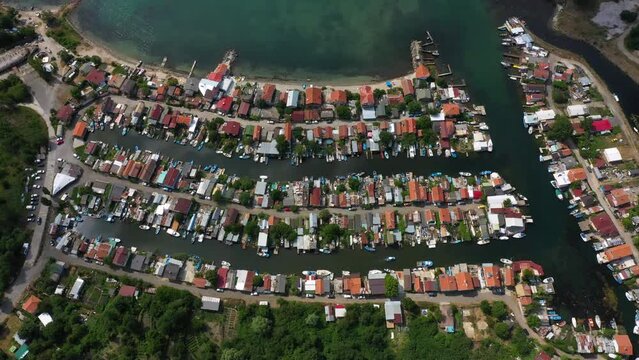 Fishing cottage with boat hus cabins at the ocean or sea on small sandy island. Villages or town of wooden houses in Chengene Skele in Burgas, Bulgaria. Aerial drone flight over a fishing village. 