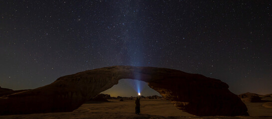 Beautiful view of the starry sky above the stone arch. Wadi Rum, Valley of the Moon, Jordan.