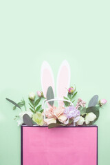 The Easter bunny's ears peek out of a bag of flowers