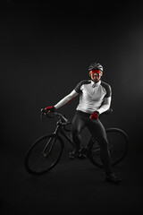male cyclist with road bicycle on black background