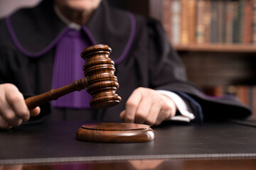 Judge in the courtroom. Judge with the wooden gavel in his hand. Law and justice theme.