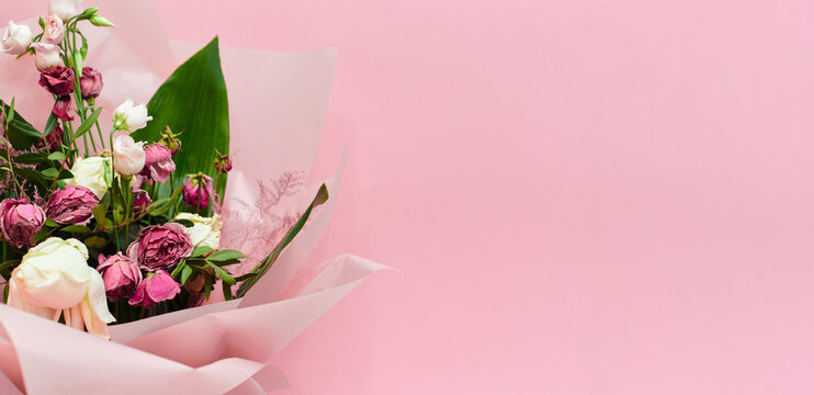 bouquet of dying flowers on pink background