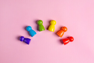 Colorful Waldorf wooden human figure rainbow in a montessori teaching pedagogy on pink background, kid play concept