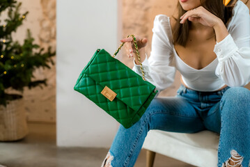 Stylish women's green handbag. Trendy outfit woman with green bag. Girl with bag over his shoulder...