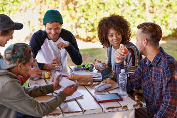 Good social vibes on campus. A group of friends around an outdoor table.