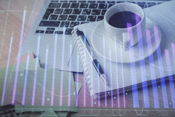 Double exposure of forex chart drawing and desktop with coffee and items on table background. Concept of financial market trading