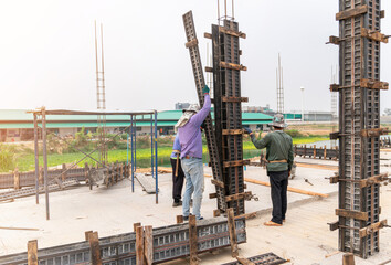 Construction workers installing formwork column pillar - obrazy, fototapety, plakaty