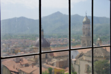 In the foreground, the Annunziata complex seen through a glass window and in the background the...