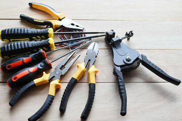 Electrical hardware tools for general repair and maintenance isolated on wooden background closeup.