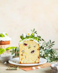 Happy Easter. Traditional Russian or Ukrainian Easter cake Kulich with meringue icing, candy shaped eggs and flowers. Holiday concept.