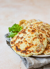 Fresh naan bread with avocado and sprouts, concrete background. Traditional homemade wheat flour flatbread on a plate.