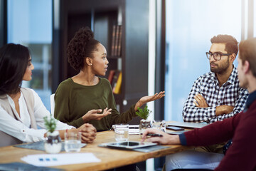 Trying to impress her boss with her ideas. Shot of a group of businesspeople having a meeting in the boardroom.