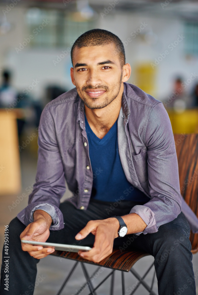 Poster I use it for work and entertainment. Portrait of a handsome young man using a digital tablet in an office.