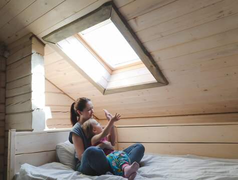 Portrait of enjoy happy family mother and little girl hugging, smiling, playing and having good time in a cozy room at home.