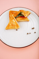 Baked meat and vegetables crepe pink background