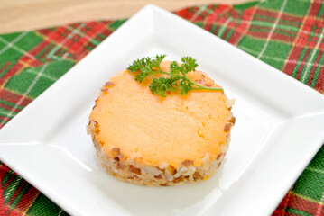 Close-Up of a Cheddar Cheese Log with Nuts Slices on a Plate 