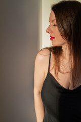 Naklejka premium A young woman with red lipstick in a black dress.