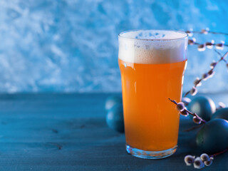 Limited edition craft beer pint glass on blue background, painted Easter eggs. The concept of...