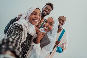 A group of multiethnic students take a selfie with a smartphone on a white background. Selective focus 