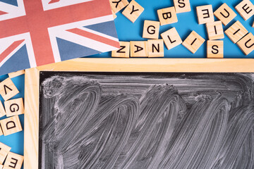 Chalkboard with white streaks next to the letters and the British flag.