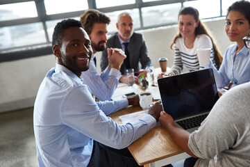 Fototapeta premium Our meetings are always productive. Portrait of a young businessman sitting around a table with his colleagues in the boardroom.