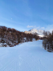Winter landscape with mountain slopes covered with snow. Ski resort in the Italian Alps. Winter holidays destination.