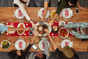 Food is best enjoyed with friends. Cropped shot of a group of people making a toast at a dining table.