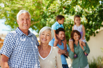 The love of a family is lifes greatest blessing. Shot of a happy senior couple with their family standing in the background.