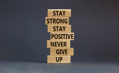 Never give up symbol. Wooden blocks with concept words Stay strong stay positive never give up....