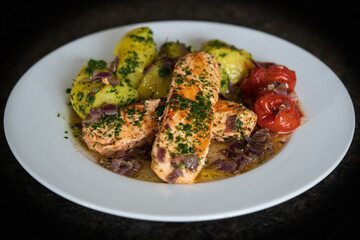 healthy and fresh cooking at home -roasted salmon fillet with potatoes in olive oil, red onions and cherry tomatoes