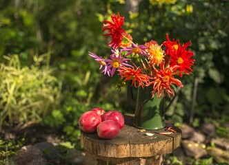 flowers and apples on a wooden table